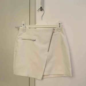  - Fin somrig vit kjol med dragkedjedetaljer. Ej genomskinlig!