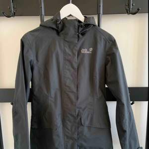 Jacket - waterproof & windproof Brand: Jack Wolfskin Size: S Colour: Charcoal Grey  Lots of nice little details, like wooden buttons.  Breathable. Weatherproof. You can make it tighter in the back.  Lots of pockets.  Hardly ever worn. Great condition. 