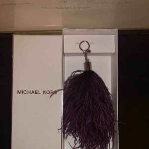  - MK Nyckelring eller detalj till väska Färg: Lila Stl: XL Skick: oanvänd Nypris: 900kr 