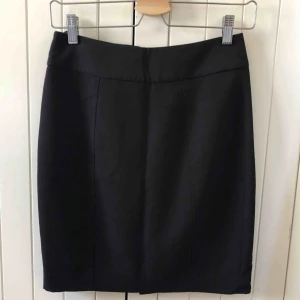 - Figurnära kjol med snygga sömmar och liten slits baktill.  Dold dragkedja och knapp bak. mycket bra skick! Material: 70% Polyester, 20% Viscos, 5% Elastan. Foder: 95% Polyester, 5% Elastan. Upphämtas i centrala Uppsala. Portot tillkommer vid frakt, 36kr