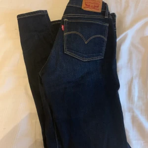 Mörkblå Levis, storlek 25 - Blå jeans i fint skick. Som nya! 100kr frakt och bud från 300kr. Köpt för 999kr