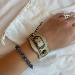 Balenciaga armband - Armband från balenciaga! Dustbag ingår och självklart äkta!! Superfint beiget och välanvänt vilket ger den ett unikt intryck
