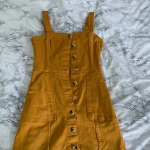 En gul klänning  - nästan oanvänd. Den passar bra på en xs eller liten s. Från hm bruna knappar, jens material 