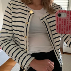 Blåvit kofta med guldknappar - Gullig blåvit kofta med guldknappar vid magen och i slutet av armarna även en liten ficka på varje sida. Avskuren nertill och lite croppad. Från Holly & White. Väldigt bra skick! Köparen står för frakten (: