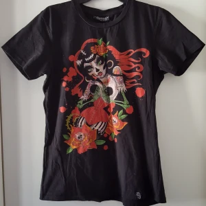  - Svart t-shirt med tryck. Kan skickas.