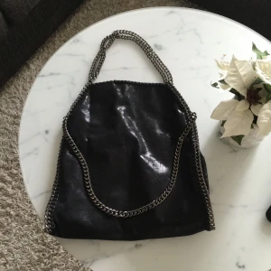  - Svart glansig väska med silver axelband! Använd ett fåtal ggr! Passar till allt! Köparen står för frakt 