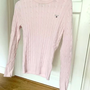 Gant kabelstickad tröja - Fin ljusrosa kabelstickad tröja från gant i storlek XS. Fint skick då den knappt är använd. Köpt för 1000 säljs för 250+ frakt