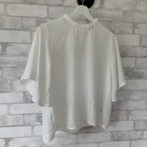 Vit blus - Jättefin blus med hög ringning! Väldigt fin i materialet och skön att ha på sig (passar nog bättre på någon med mindre byst). Använd ett fåtal gånger och är i nyskick! Säljer pga inte min stil längre <3 (samfraktar så kolla gärna in mina andra annonser)