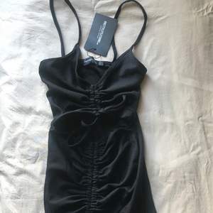 Jättefin svart klänning med fina detaljer från pretty little thing i storlek 38. Aldrig använd 