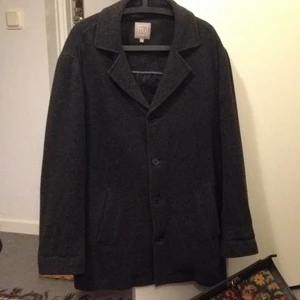  - Rak, unisex höstkappa i ullblandning. Grå och fin och håller en varm i rusket. Strl. M. 