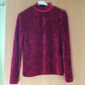  - Röd sammetströja med polokrage. Ej storleksmärkt men uppskattar den till en S.  Kan mötas i Uppsala, annars står köparen för frakt:)