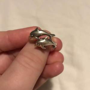 Jättefin silverpläteras ring med delfinmotiv. Har silverstämpeln 925 på insidan. Storleken är 17mm i diametern.