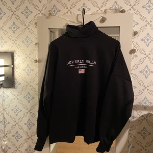 Polotröja - En polo-sweatshirt med tryck från boohoo. Knappt 1år gammal och använd 1-2 gånger. Vid passform nedtill och resår i ärmslutet, något tight i halsen. 