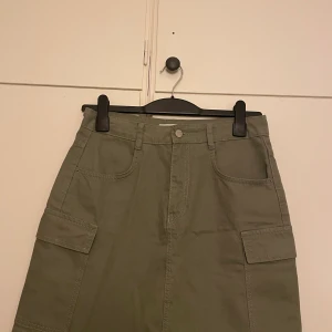 Jeanskjol - Militärgrön jeanskjol. Har en matchande jacka som jag också säljer. Använd 1 gång. 