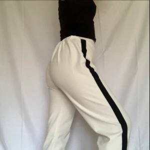 VITA BYXOR MED SVART DETALJ - Byxor från NLY TREND😍 i bra skick! Använd några få gånger.  STRL S🥰 Har svart sträck på varsin sida 🤍🖤 Lite scrunch där bak så rumpan framhävs lite😉 Stretchig material, jättesköna  Jag är 1.60m och den sitter perfekt på mig✨ Ha gärna med vita trosor 🤍