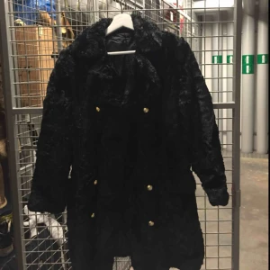  - Varm och tät vintagekappa, perfekt för vintern. Fint skick. Snyggt glansig, osäker på om det är fuskpäls eller päls. Knappar i guld, en knapp fattas men sys enkelt på (därav lågt pris).  Möts upp i Stockholm efter överenskommelse.
