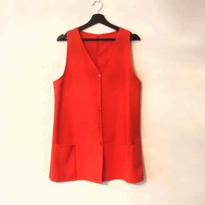 Röd kort 60-tals klänning med knappar och fickor. Made in Denmark 100% polyester.