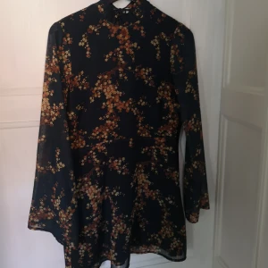  - Mönstrad klänning med öppen rygg och knyt i nacken 