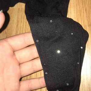  - Stretchigt material i svart lite genomskinligt med små ”diamant pärlor” på, dom e väldigt stretchiga så passar xs till liten m eller stor s