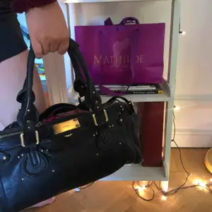 Handväska från Chloé i modellen Paddington black. Köptes i Frankrike sommaren 2016, därav några små slitningar på handtagen, men väskan är förövrigt i bra skick. Den köptes för 4999kr och mitt pris är 2450 men det går att diskutera! 