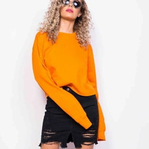  - Orange croppad sweatshirt i färgen electric orange från MadLady. Aldrig använd, lappar sitter kvar på plagget. Storlek S/M. Köparen står för frakten - 50kr