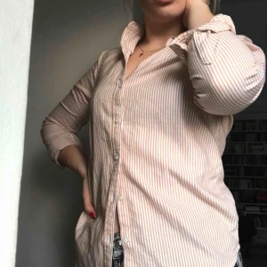  - Fin skjorta med senapsgula ränder. Passformen sitter fint efter ens kurvor och skär in i midjan för en mer formlig kropp. 