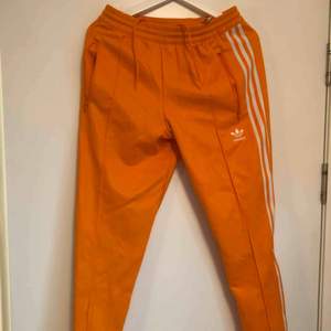 Fräscha orangea Adidas tracksuit-byxor!!! Nyskick, använda 1 gång! Kan mötas upp, alternativt posta, frakt ligger dock på köparen. Swish