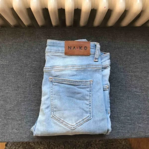  - Ljusblå tjata jeans från NAKD med ett vagt streck i mitten av byxorna, storlek 38, använda 2-3 gånger 