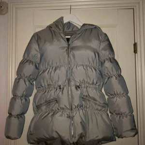 - Silvrig dunjacka ifrån zara girls, den är i barnstorlek men passar även en S. Den är åtdragbar i midjan o har snygg detalj på luvan. 