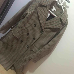  - Beigerutig kappa från HM i skönt tjockt material. Storleken passar bäst en S, passar även M och XS. Aldrig använd, prislapp sitter kvar!