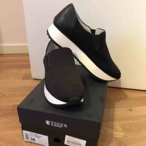  - Riktigt snygga svarta skor från Tiger, tight passform, skön läder beklädd häl och ovandel i tyg sydd i stilrent mönster. Hög sula med räfflad undersida, väldigt mjuk sula i läder :) 