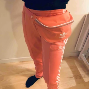  - Crossbody bag/fannypack i peach/gammelrosa. Finns ett helt set med byxor och jacka. Hela setet 700 kr. Pris exl frakt 