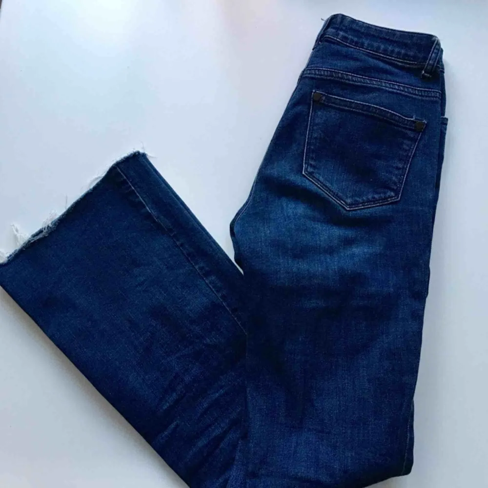 Mörkblåa jeans med bootcut, avklippta längst ner. Jeans & Byxor.