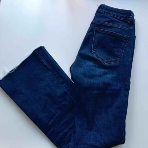  - Mörkblåa jeans med bootcut, avklippta längst ner