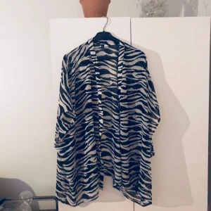  - Transparent zebrafärgad kofta/blus. Går att knäppa med knappar om man vill.