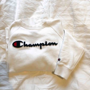  - Vit champion sweatshirt med text upptill, märket på armen och två fickor på magen, väldigt lite använd och mycket bra skick! 