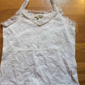  - Vitt basic linne med spets upptill. Märkt som M men mer en S. Frakt: 42 kr