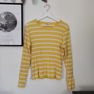 Långärmad tröja från Cubus - Gul- och vitrandig ribbstickad tröja med lettuce sleeves. Bra skick. Gratis frakt!