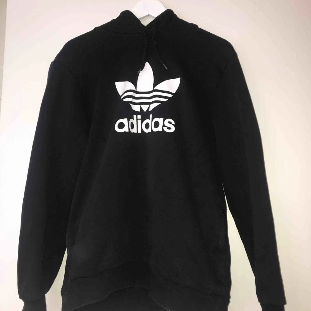 Svart Adidas hoodie med fickor. Köpt för ungefär ett år sedan för 500 kr, säljs för 300 kr och i priset ingår frakt. Den är knappt använd och är i väldigt bra skick.. Hoodies.