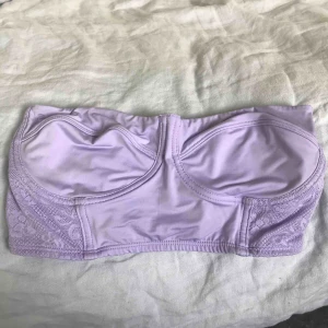  - Ljuslila topp i baddräktsliknande tyg med spets i ryggen (bild 2). Kan användas som både bikiniöverdel eller topp. 