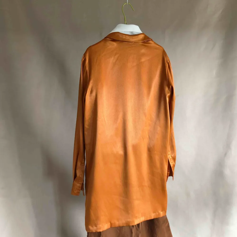 Orange/skimrande Skjortklänning i gott skick från na-kd. Vid fler intressenter går köpet till den som budar högst. Klänningar.