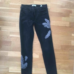  - Gråsvarta jeans med fjädertryck. Aldrig använda pga fel storlek. Bra kvalitet och inga slitningar, de är som nya. Pris kan diskuteras! 