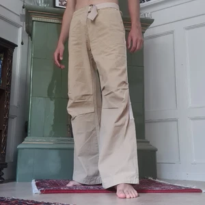Beiga Levi's byxor - Beiga bootcut liknande Levi's byxor i helt nytt skick med prislapp kvar, reglerbar midja och byxbenen går att knäppa upp så att de blir shorts. Ca 103cm i längd och ca 78cm runt midjan.  