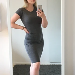 Klänning  - Snygg grå t-shirtklänning i stretchigt material. Väldigt skön och endast använd ett fåtal gånger!🥳 