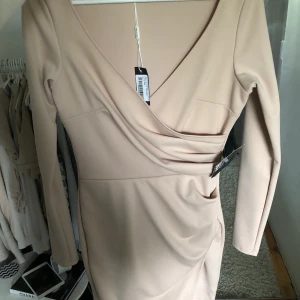 Klänning - Ny oanvänd beige klänning från Nelly med prislapparna, kvar kan fraktas, frakt ingår ej i priset