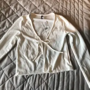 En vit knyt-tröja från H&M. Aldrig använd så lappen finns kvar. Storlek M men passar säkert S och L beroende på vilken passform man vill ha. Säljer för minst 110 kr + frakt. (:
