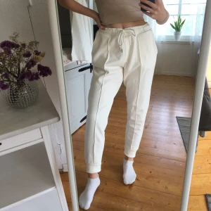 Mjukisbyxor fr. Vero Moda - Vita mjukisbyxor från Vero Moda som är helt oanvända. Liknar kostymbyxor då de har en söm på benen och fickor på rumpan (dock bara fejkfickor). Frakt tillkommer på 60kr och betalas via Swish. 