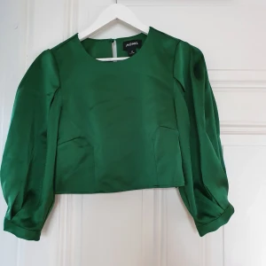 Smaragdgrön blus - Superfin silkig blus i smaragdgrön färg. Ganska kort men väldigt fin till en hög byxa. 