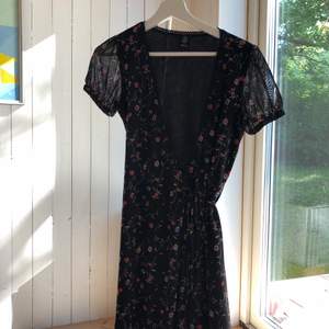 Söt svart blommig wrapklänning från UO, storlek S. Smickrande modell med söta detaljer. Frakt tillkommer🌟