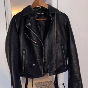 Svart skinnjacka - Svart skinnjacka i bikermodell. Ej äkta skinn men väldigt fint material. Använd 1 gång. Kan skickas spårbart 🥰